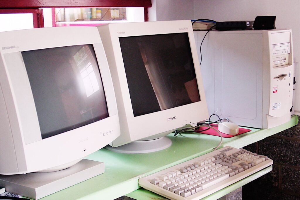 Fotografia mostrando computador em 2004, com gabinete torre e dois monitores CRT