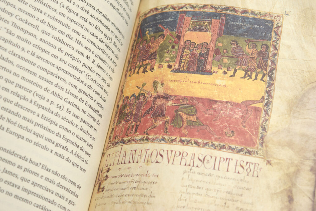 Livro aberto mostrando página de texto e reprodução de manuscrito e iluminura colorida