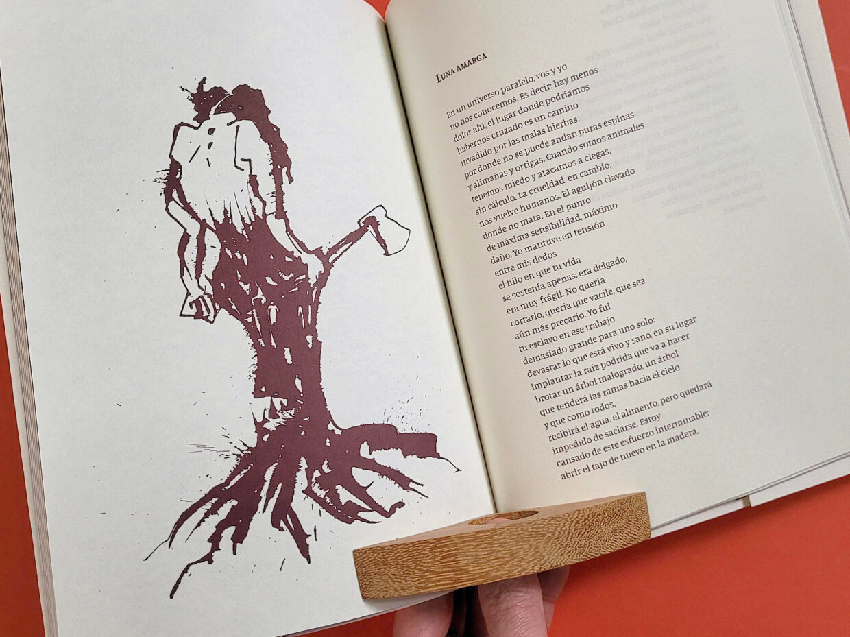 Livro aberto mostrando desenho de mulher segurando machado e pernas em forma de tronco de árvore