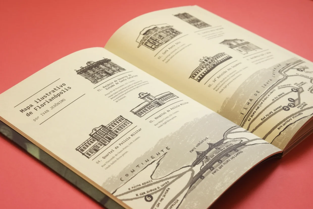 Foto do livro aberto mostrando mapa com pequenos desenhos de prédios e na parte de baixo a localização desses imóveis em Florianópolis